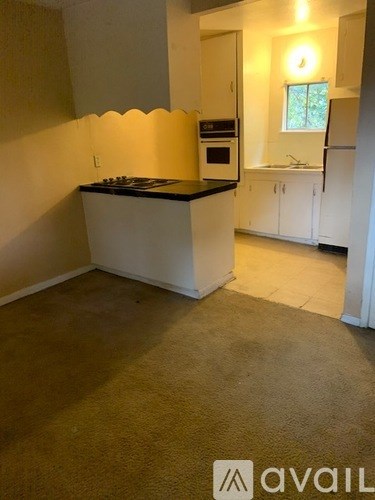 A kitchen with white cabinets and a black countertop.