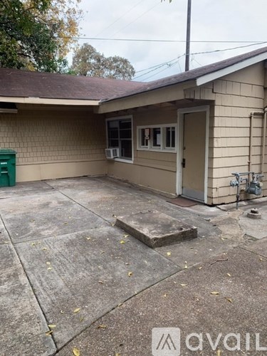 A small house with a green container in front.