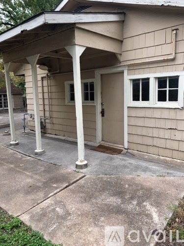 A beige house with a white door and windows.