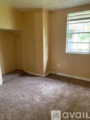 A room with a carpeted floor and a window letting in natural light.