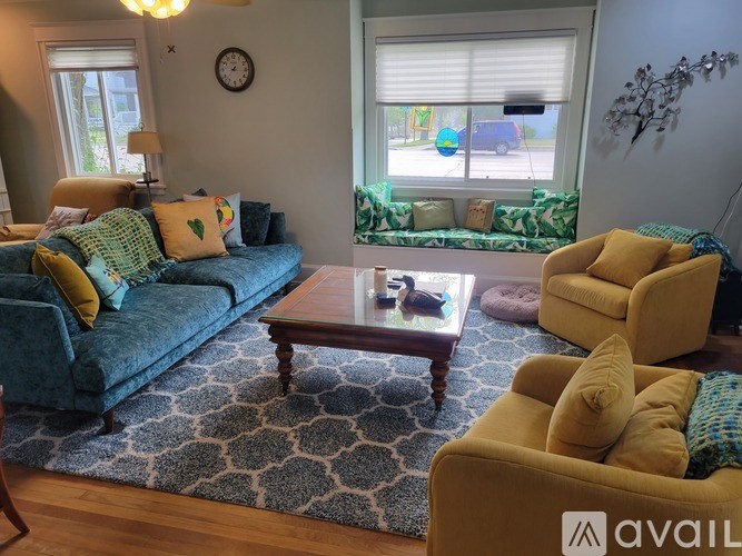 A living room with a blue couch, a coffee table, and a yellow chair.