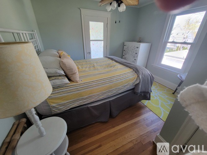 A bedroom with a bed, nightstand, and lamp.