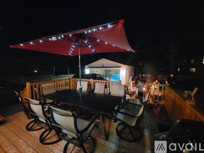 A patio with a table and chairs under a red umbrella.
