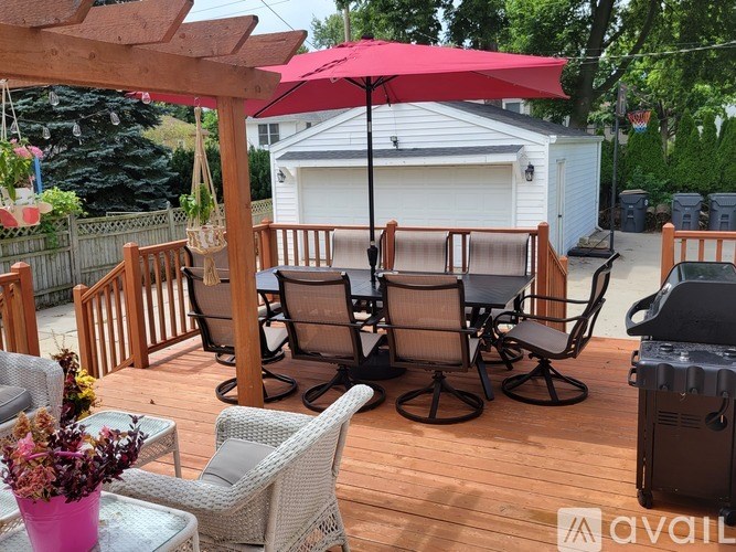 A patio with a table, chairs, and an umbrella.