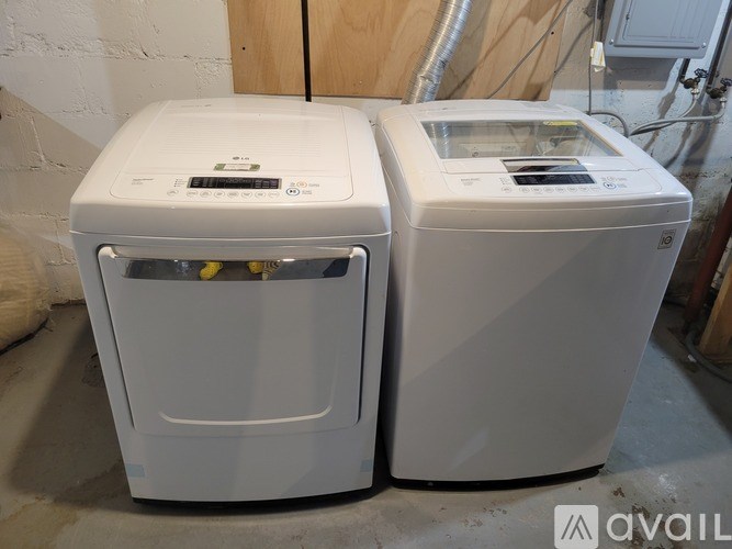 Two white front loading washing machines in a room.