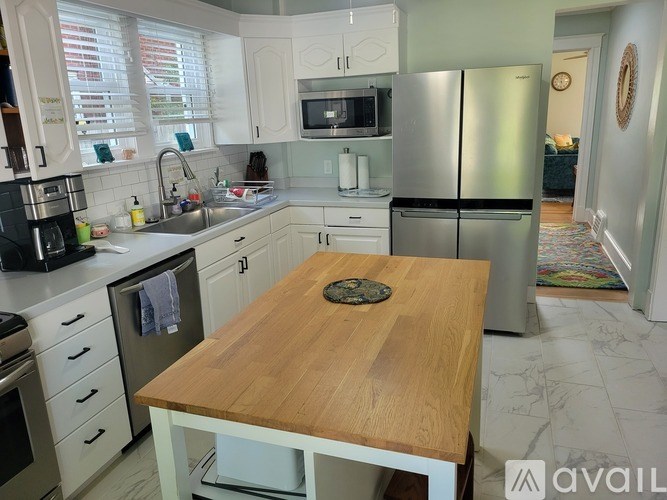 A kitchen with a wooden table in the middle.