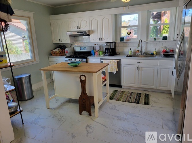 A kitchen with a white counter and a wooden spatula on it.