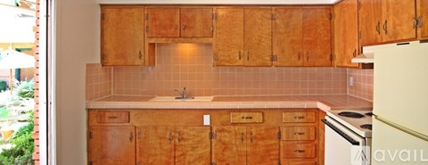A kitchen with wooden cabinets and a white refrigerator.