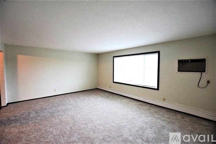 A room with a window and a flat screen TV mounted on the wall.