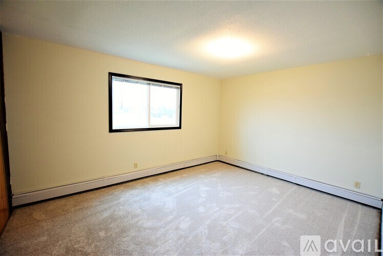A room with a window and carpeted floor.