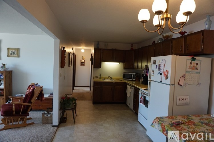 A kitchen with a refrigerator, sink, and cabinets.