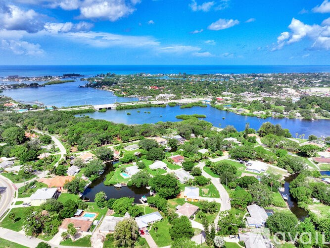 A bird's eye view of a coastal town with a body of water and houses.
