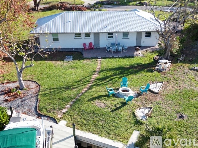 A white house with a green lawn and a tree.