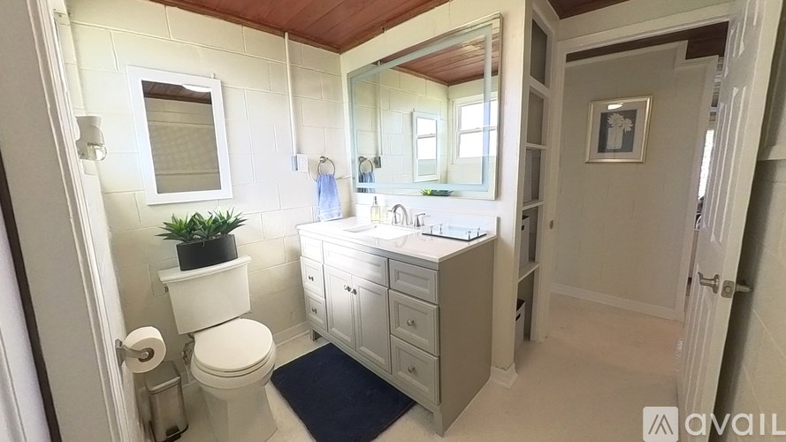 A bathroom with a toilet, sink, and mirror.