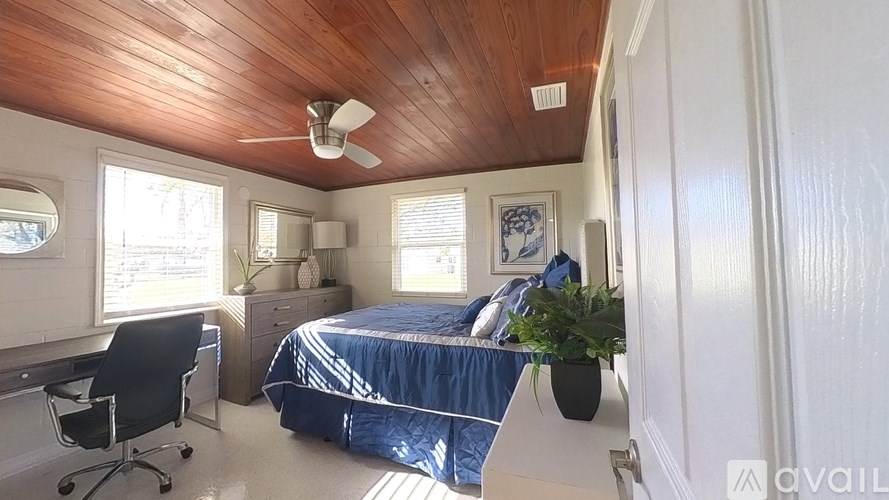 A bedroom with a bed, desk, and chair.