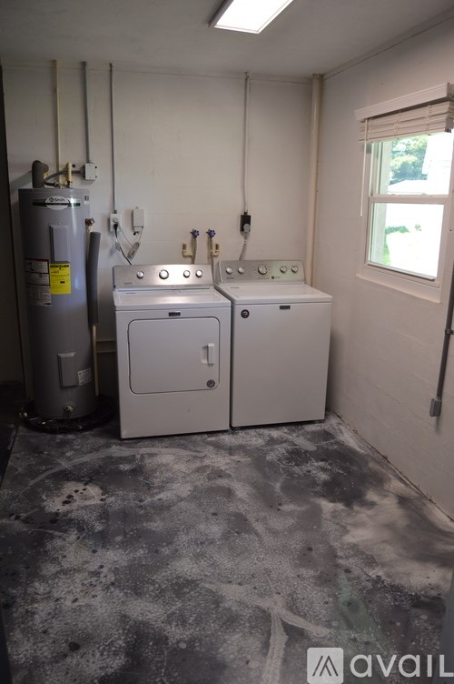 A dirty utility room with a washer and dryer.