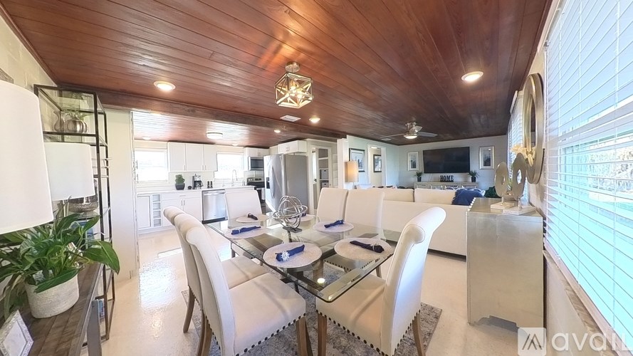 A modern living room with a wooden ceiling and white furniture.