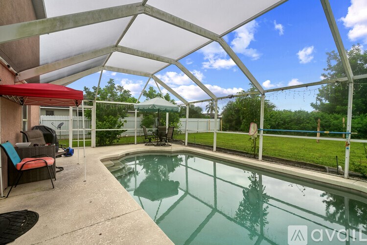 A pool area with a glass enclosure and a red awning.