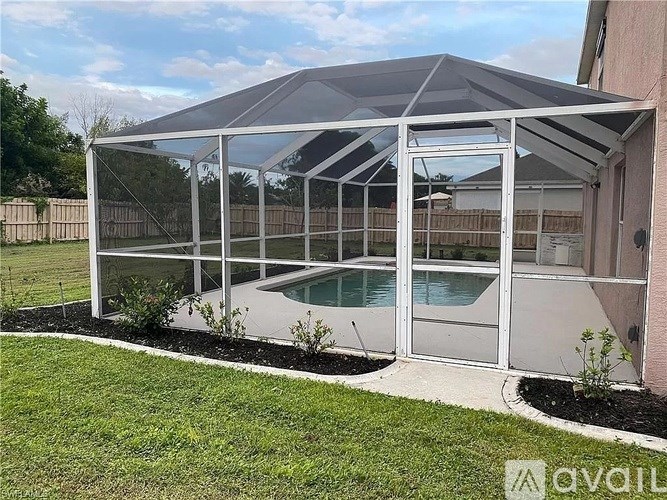 A pool enclosure with a glass door and a white roof.