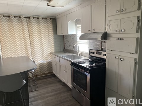 A kitchen with a black stove top oven and white cabinets.