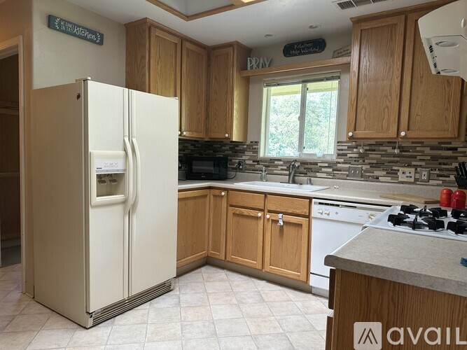A kitchen with a white fridge and wooden cabinets.