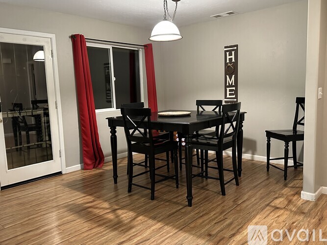 A dining room with a wooden table and chairs.