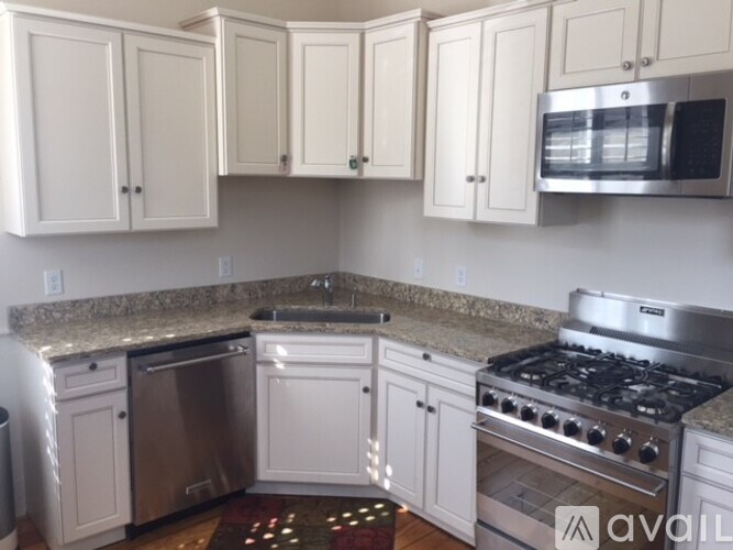 A kitchen with white cabinets and stainless steel appliances.