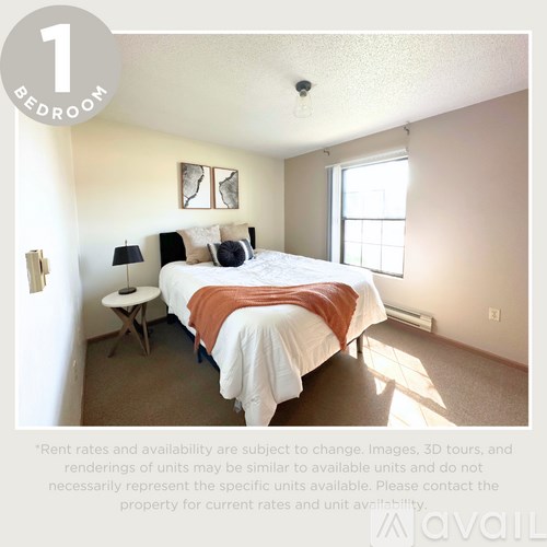 A bedroom with a bed, nightstand, and lamp.