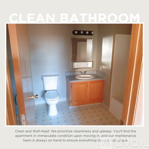 A clean bathroom with a toilet, sink, and mirror.