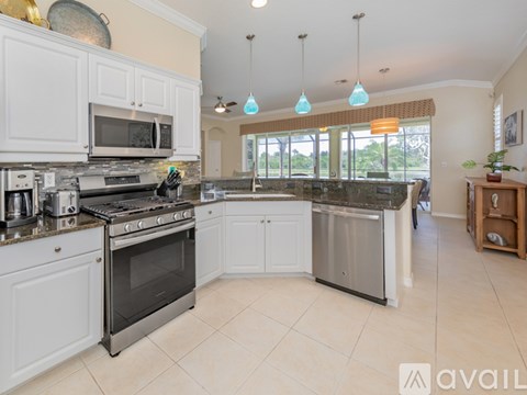 A kitchen with white cabinets and a black stove top oven.