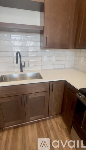 A kitchen with wooden cabinets and a stainless steel sink.
