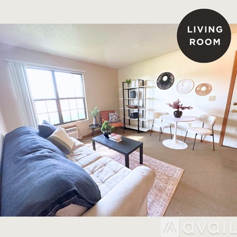 A living room with a couch, a coffee table, and a dining table.