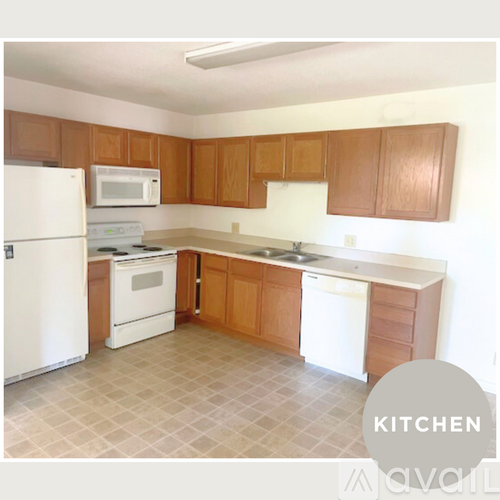 A kitchen with white appliances and brown cabinets.