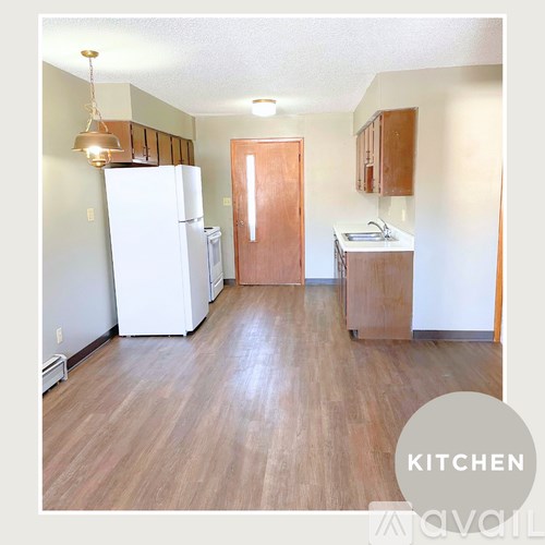 A kitchen with white appliances and wood floors.