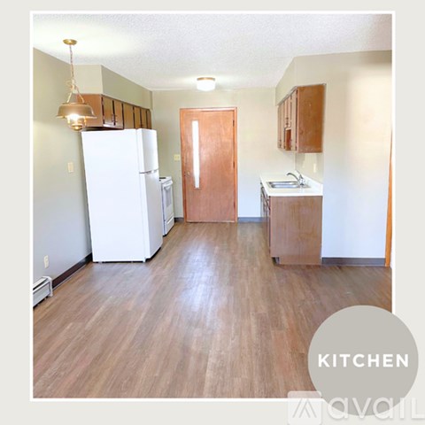 A kitchen with white appliances and wood floors.