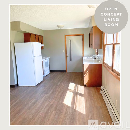 A kitchen with a white refrigerator and wooden floors.
