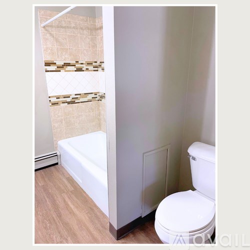 A white toilet in a bathroom with a tiled shower.