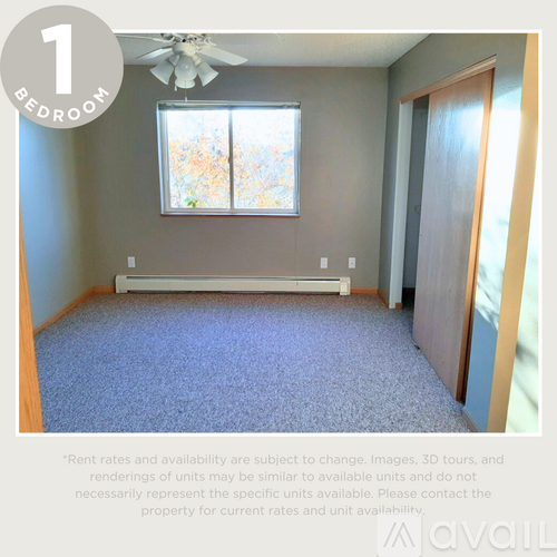 A bedroom with a window and a carpeted floor.