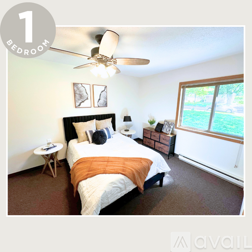 A bedroom with a bed, a ceiling fan, and a window.
