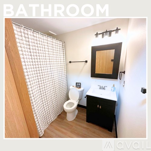 A bathroom with a toilet, sink and shower.