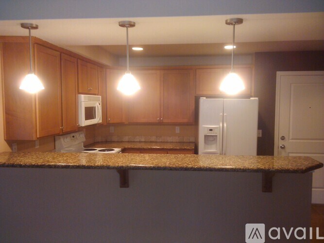 A kitchen with brown cabinets and granite countertops.