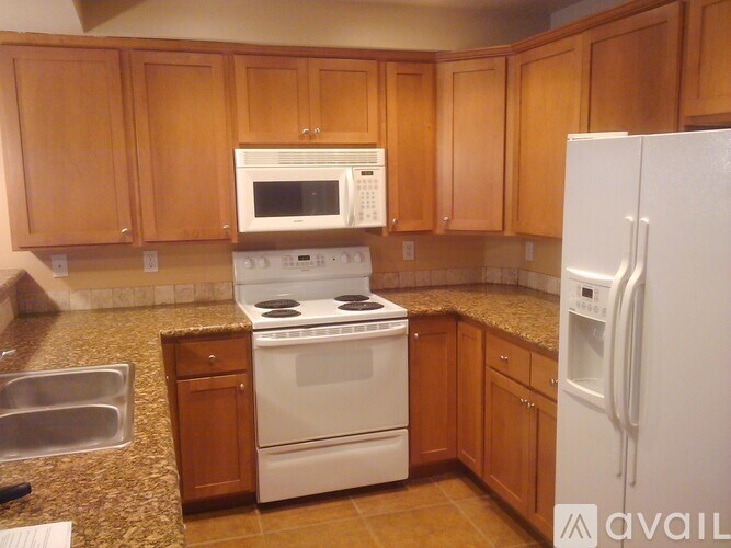 A kitchen with wooden cabinets and a white refrigerator.