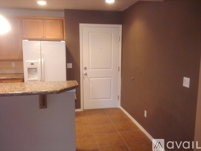 A kitchen with brown cabinets and a white refrigerator.