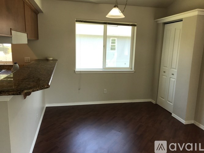 A room with a brown countertop and a window with white blinds.
