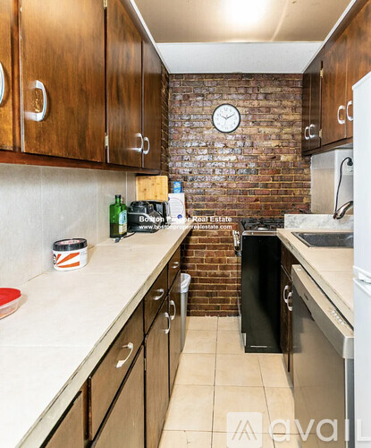 A kitchen with a brick wall and a clock on it.