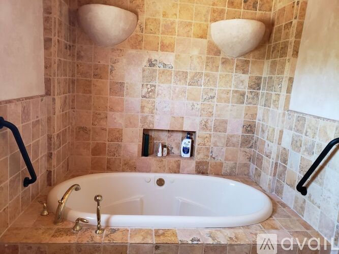 A bathroom with a tiled wall and a bathtub.