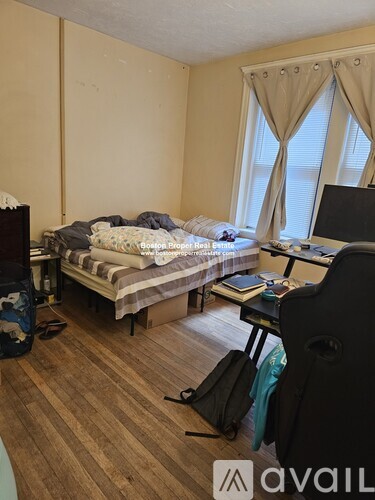 A room with a bed, desk, and chair.