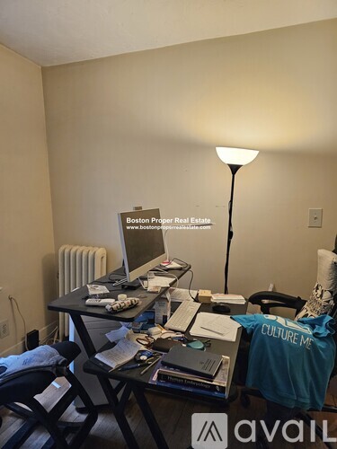 A room with a desk and a chair with a sign that says "Boston Proper Real Estate".