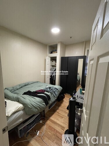 A bedroom with a bed, a wardrobe, and a desk.