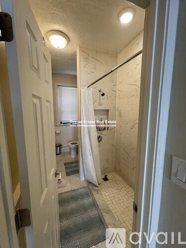 A bathroom with a toilet, sink, and shower.
